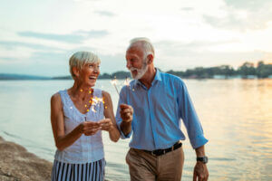 Older couple on lake shore with sparklers