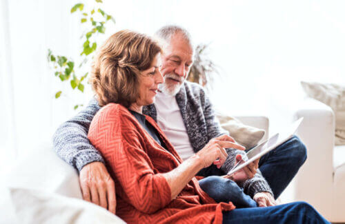 Senior couple on couch looking at tablet